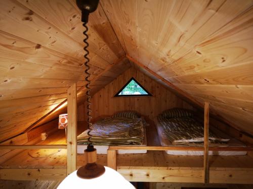 een kamer met 2 bedden in een boomhut bij Bakasana in Ruciane-Nida