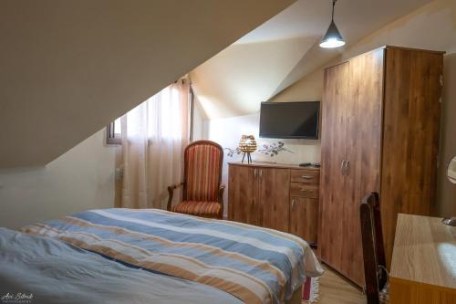 a bedroom with a bed and a tv and a table at הבית של רחל in Qasrîne