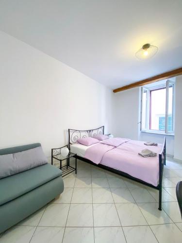 a bedroom with a bed and a couch at Apartmani DA in Piran
