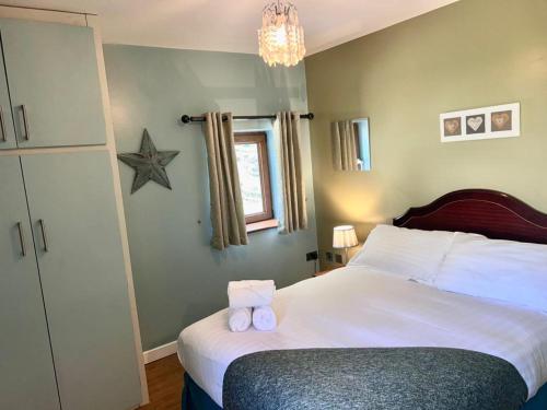 a bedroom with a bed with two towels on it at Pass the Keys The Pumphouse Holiday Cottage in Kidwelly