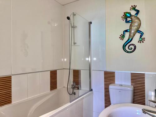 a bathroom with a shower and a toilet and a sink at Pass the Keys The Pumphouse Holiday Cottage in Kidwelly