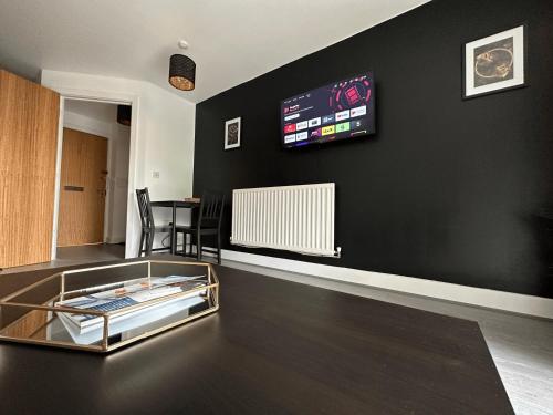 a living room with a table and a tv on the wall at Relocators - Parking - Central in Birmingham
