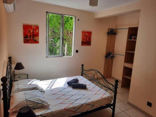 a bedroom with a bed in a room with a window at Villa Marilou - Les pieds dans l'eau in Quartier du Fond Fleuri