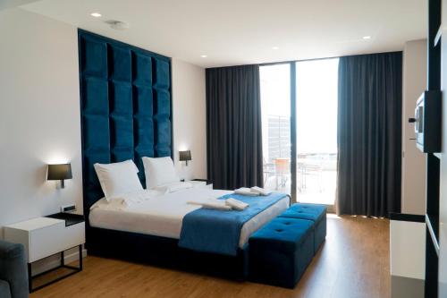 a bedroom with a large bed with a blue headboard at Hotel Blue Sky in Sarandë