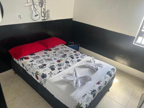 a bedroom with a bed with white sheets and bows at El Amanecer Parque Del Agua in Manizales