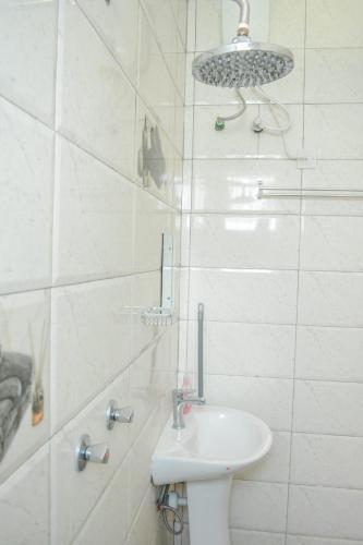 a white bathroom with a sink and a toilet at Lux Suites Ganjoni Studio Apartment in Mombasa