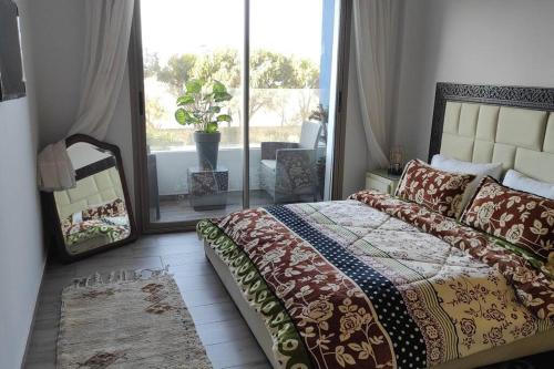 a bedroom with a bed and a large window at Luxueux appartement en résidence de 2 chambres A2 in Essaouira