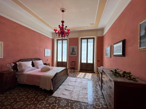 a bedroom with pink walls and a bed and a chandelier at Residenza Porta Brescia in Peschiera del Garda