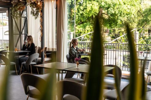 two women sitting at tables in a restaurant at Horti 14 Borgo Trastevere Hotel in Rome