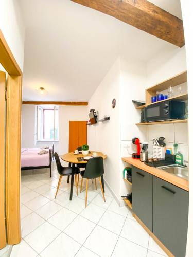 a kitchen and dining room with a table and chairs at Apartmani DA in Piran
