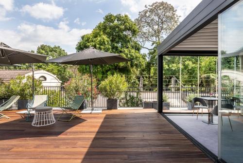 an outdoor deck with chairs and umbrellas at Horti 14 Borgo Trastevere Hotel in Rome