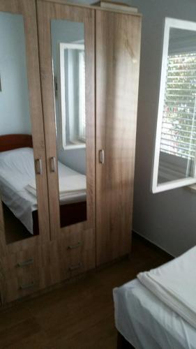 a bedroom with a wooden cabinet with a mirror at Villa Teodora in Donja Vrućica