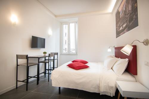 Un dormitorio con una cama con almohadas rojas y una mesa. en Your Vatican Suite, en Roma