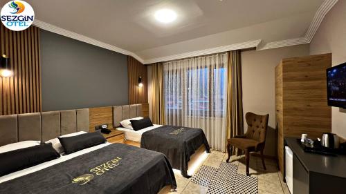 Cette chambre comprend deux lits et une télévision. dans l'établissement Sezgin Hotel, à Uzungöl