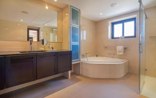een badkamer met een bad, een wastafel en een bad bij 5 bed-villa with golf court view in Marbella