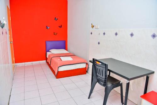 Habitación pequeña con cama, mesa y silla en T FAMILY HOTEL, en Klang