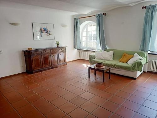 sala de estar con sofá verde y mesa en La Fiorita, en Bironico