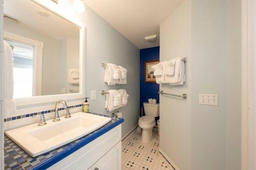 a bathroom with a sink and a toilet and a mirror at Just steps to Duval- Sleeps 10- Heated Pool House in Key West
