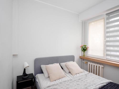 a bedroom with a bed with white walls and a window at Best Choice 2-bedroom Apartment in Płock