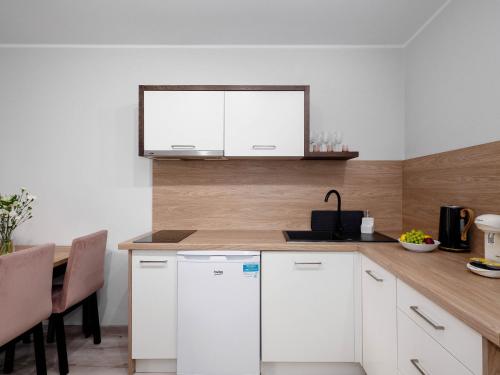 a kitchen with white cabinets and a wooden counter top at Best Choice 2-bedroom Apartment in Płock