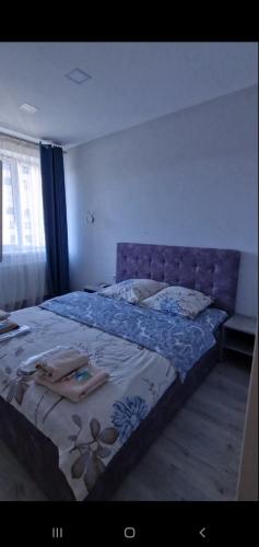 a bedroom with a bed with a blue comforter at Apartments - Viva Ukraine in Uzhhorod