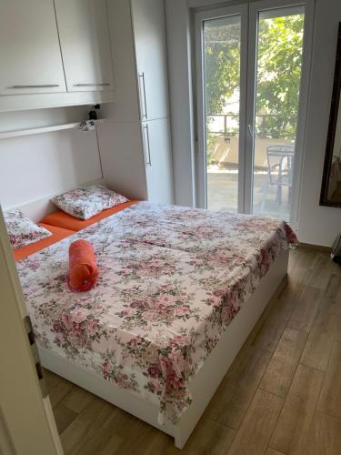 a bedroom with a bed with a flowered bedspread at Vila Nimfa in Živogošće