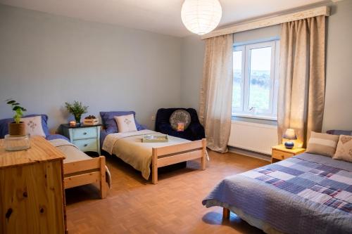 1 dormitorio con 2 camas, sofá y ventana en Contryside holiday house, for even better energy sourcing, en Detva
