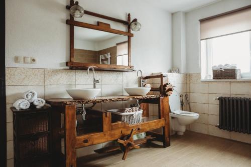 een badkamer met 2 wastafels en een toilet bij Contryside holiday house, for even better energy sourcing in Detva