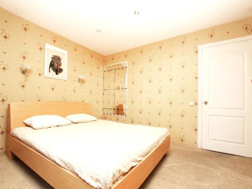 モスクワにあるApartlux Zatsepskiyのベッドルーム1室(白いシーツと壁紙のベッド1台付)
