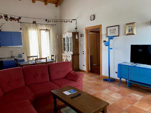 a living room with a red couch and a table at Apartment-Rosella Garda in Garda