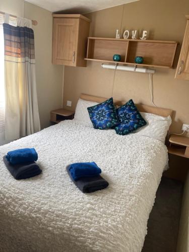 sypialnia z łóżkiem z niebieskimi poduszkami w obiekcie 3 bedroom holiday home w mieście South Hayling