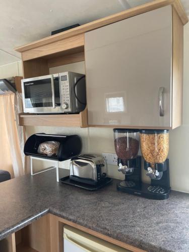 a kitchen with a counter top with a blender and a microwave at 3 bedroom holiday home in South Hayling