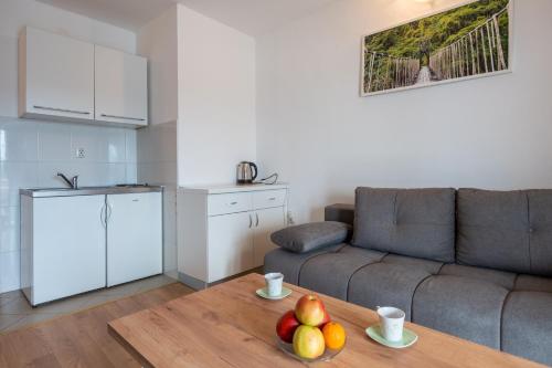 a living room with a couch and a table with fruit on it at Apartments IN in Neum