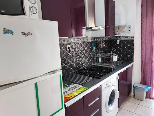 a kitchen with a sink and a washing machine at Superbe appartement à côté de la plage M'diq,Tétouan in M'diq