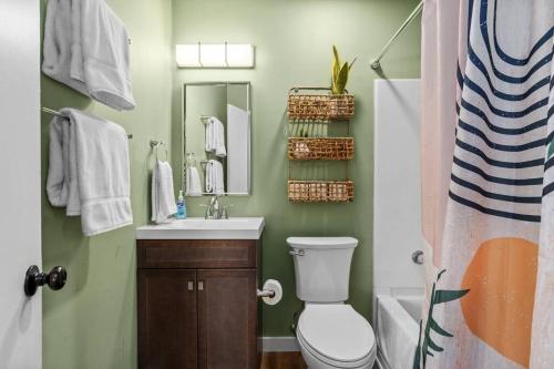 a bathroom with a toilet and a sink and a mirror at Stylish 3BR 2BA House Minutes from PCB - Book now in Panama City
