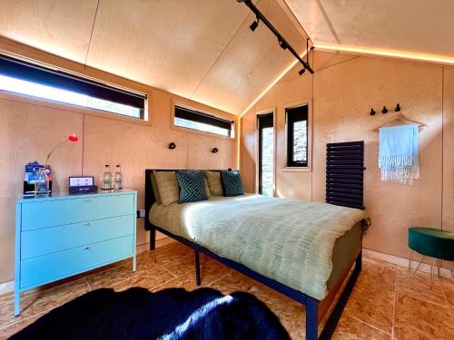 1 dormitorio con 1 cama y vestidor azul en Trossachs Barn & Cabin, en Port of Menteith