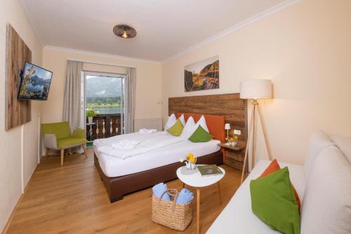 a hotel room with a bed and a couch at Hotel Seehang Garni in St. Wolfgang