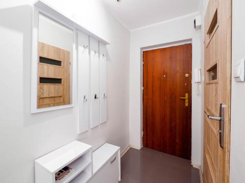een badkamer met witte kasten en een houten deur bij Sweet Honey Mieszkanie w Płocku in Płock