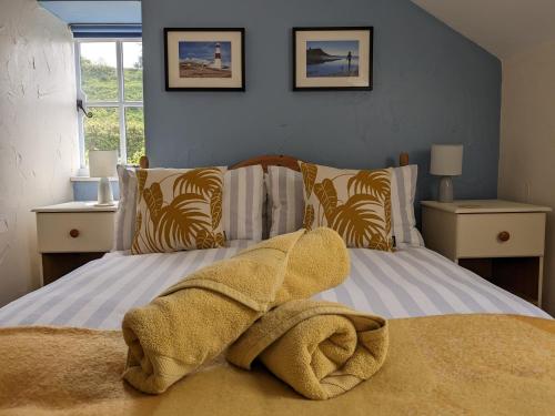 een slaapkamer met 2 bedden en handdoeken bij Barton Cottage in Bridport