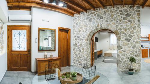 アルハンゲロスにあるAesthisis Sensational Accommodation Archangelosの石壁のリビングルーム(テーブル付)