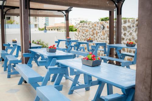 a row of blue tables and chairs on a patio at Hotel ADAZ Mediterráneo in Santa Marta