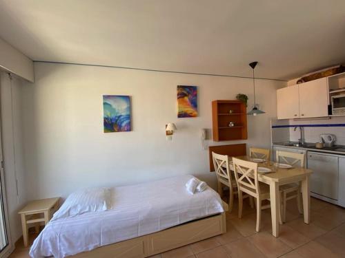 une chambre avec un lit et une table et une cuisine dans l'établissement Joli 2 pièces vue mer Parking Clim 50m plage, à Menton