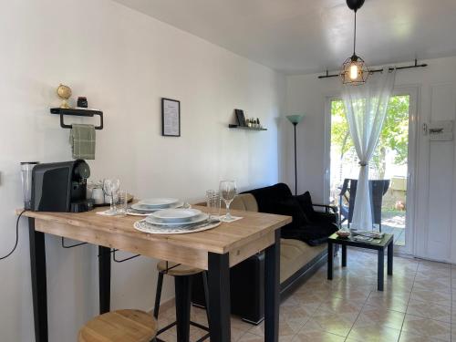 een woonkamer met een tafel met wijnglazen erop bij Studio dans lotissement calme, proche du centre in Vannes