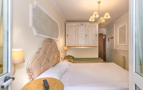 a bedroom with a bed and a table and a cabinet at Hotel Tahiti in Viareggio