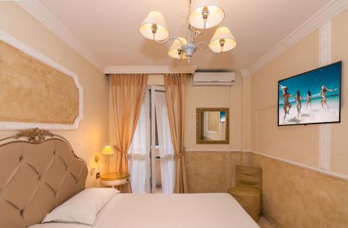 a bedroom with a bed and a chandelier at Hotel Tahiti in Viareggio
