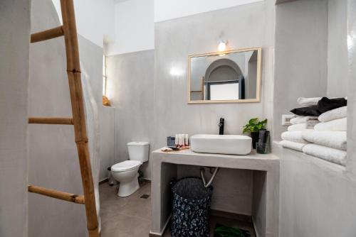 a bathroom with a sink and a toilet and towels at 1812 Caves 'n Mansion in Karterados