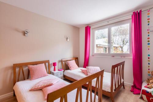 two beds in a room with pink curtains at Appartement Entre Lacs Et Montagnes in Habère-Lullin