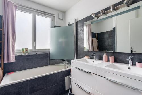La salle de bains est pourvue de 2 lavabos et d'une baignoire. dans l'établissement Appartement Entre Lacs Et Montagnes, à Habère-Lullin