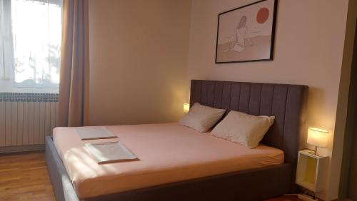 uma cama num pequeno quarto com duas lâmpadas em Olive Tree em Zadar