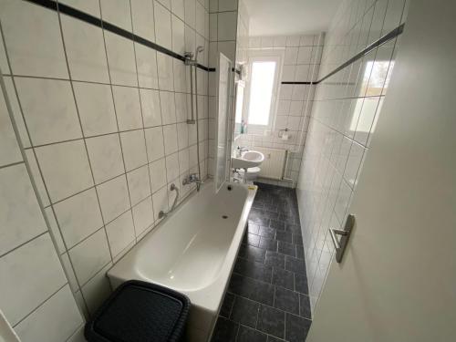 La salle de bains est pourvue d'une baignoire et d'une chaise. dans l'établissement Monteurwohnung und Ferienwohnung TMS 18 O, 